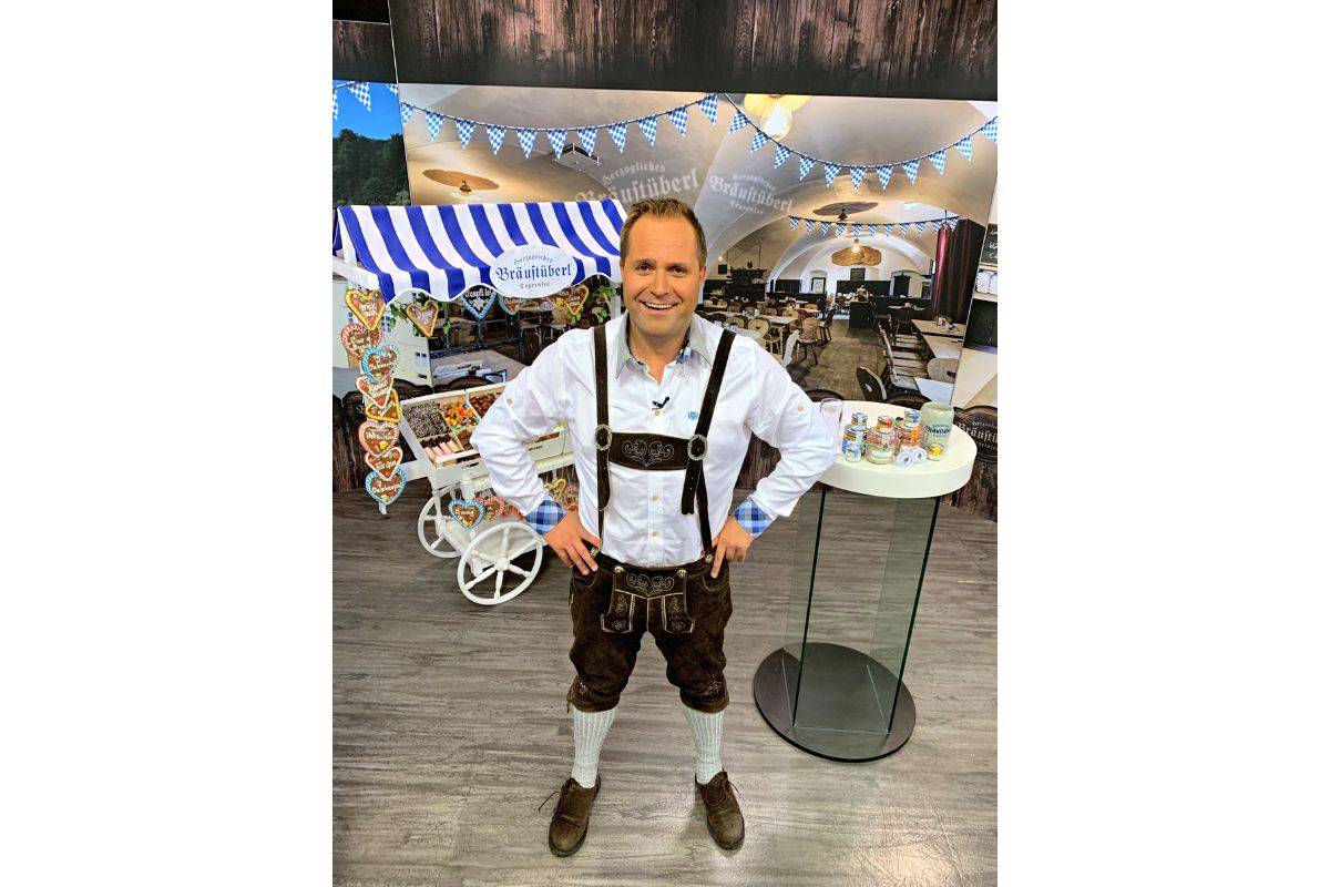 Moderator Jan in Tracht vor Wiesn-Set im Studio