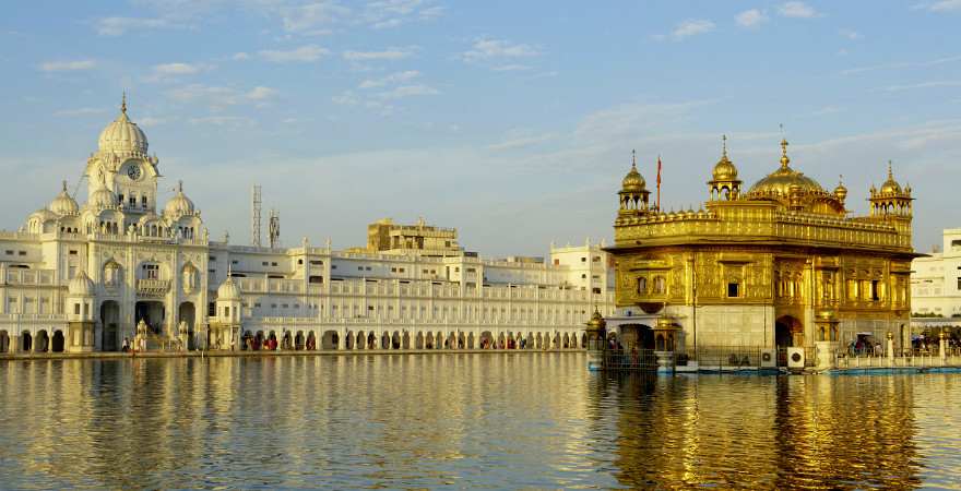 Die Fassade des Goldenen Tempels in Amritsar in Indien speigelt sich im Wasser eines Sees