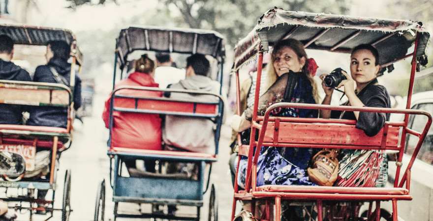 Zwei Frauen erkunden in einer Riksha eine indische Stadt