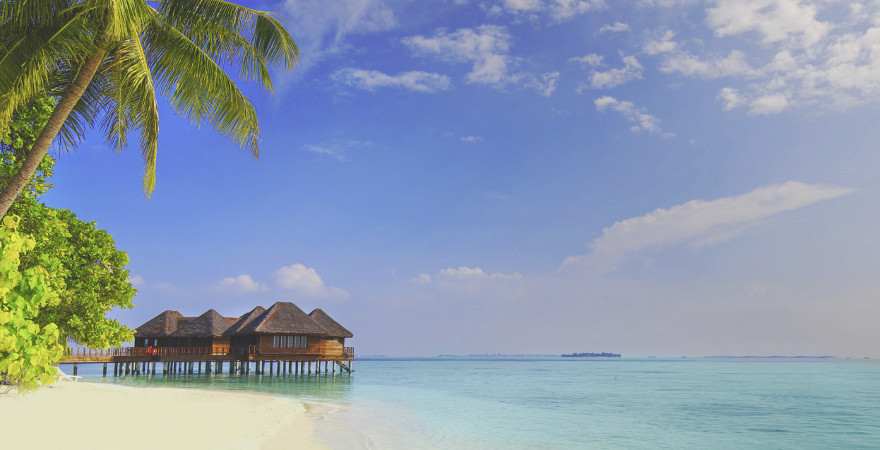 Türkisblaues Meer und romantische ÜberwasserBungalows im Hintergrund