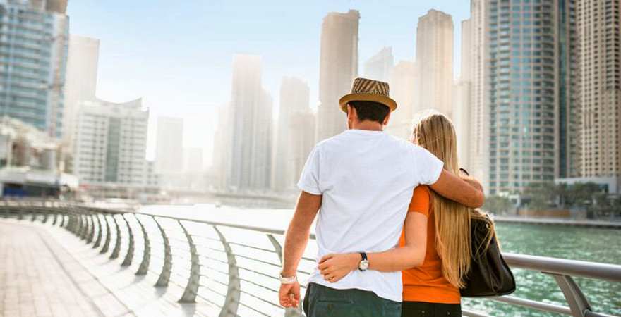 Ein verliebtes Pärchen bummelt am Wasser in Dubai