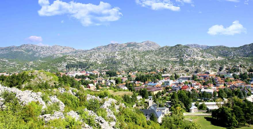Eine grüne Stadt umrahmt von Berge