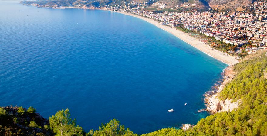 Der Kleopatra Strand bei Alanya in der Türkei mit Blick vom grünen Hügel auf Meer, Sand und Stadt 