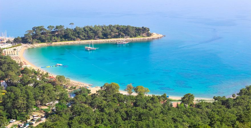 Der Moonlight Strand bei Kemer in der Türkei liegt in einer Bucht mit weißem Sandstrand und grünem Wald