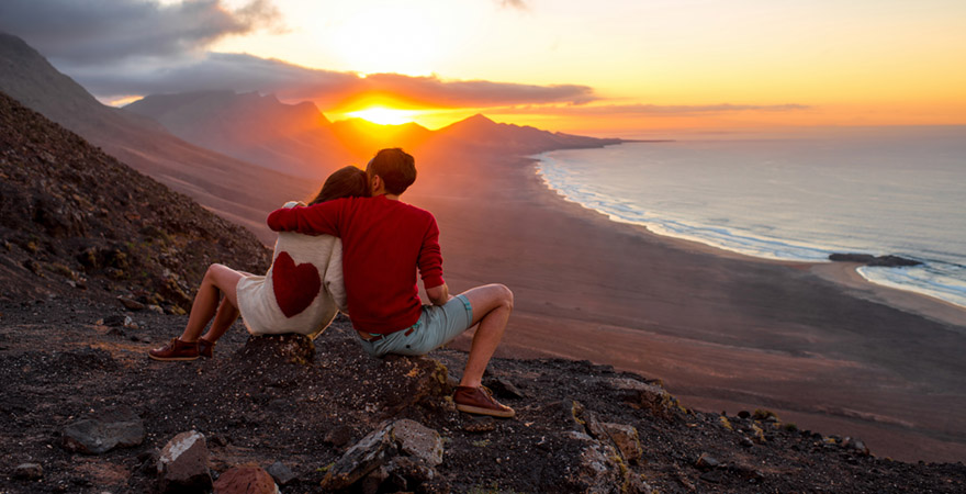 Pärchen genießt Sonnenuntergang mit Blick auf die Küste von Cofete auf der Insel Fuerteventura