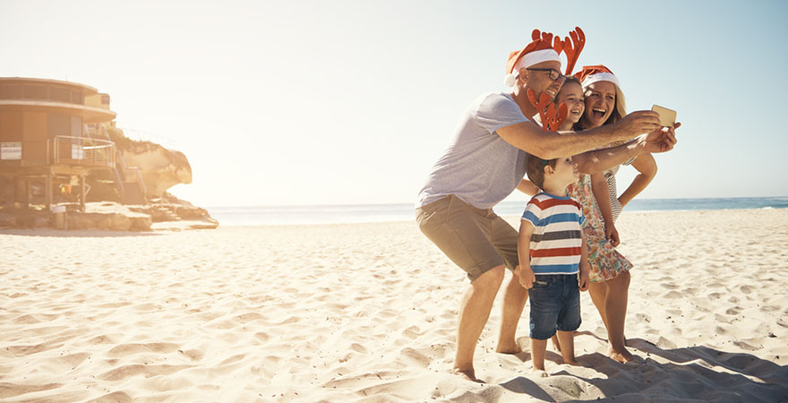 Familie, die am Weihnachtstag ein Selfie am Strand macht