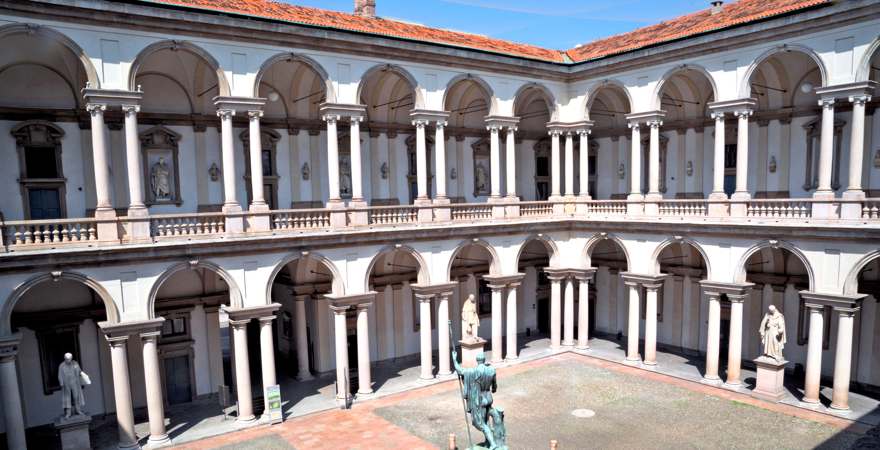 historischer innenhof mit arkaden und statue