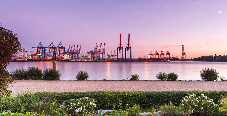 Elbstrand und Container Terminal in Hamburg bei Sonnenuntergang