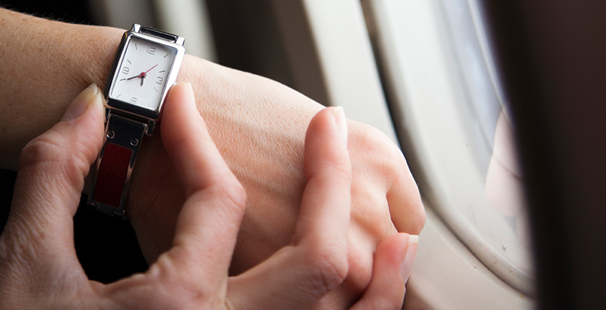 Person stellt ihre Armbanduhr im Flugzeug um