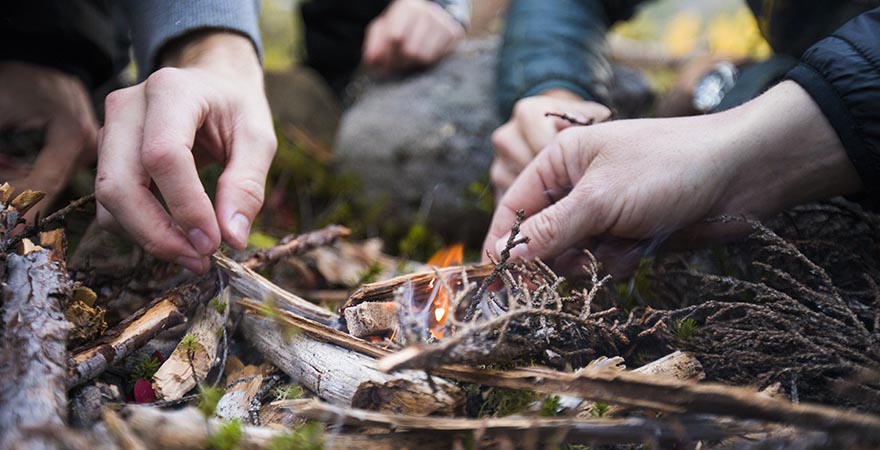 Hände, die Lagerfeuer anzünden
