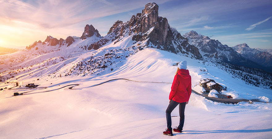 Frau vor den verschneiten Bergen der Dolomiten