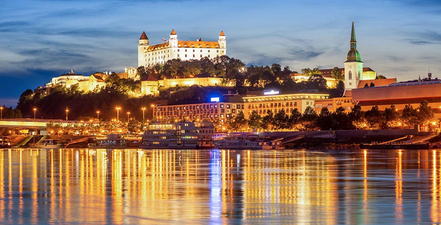 Die erleuchtete Altstadt von Bratislava in der Slowakei spiegelt sich in der Donau