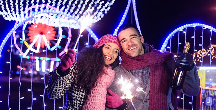Paar mit Sektflasche und Wunderkerzen im Freizeitpark