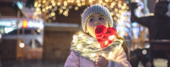 Kind auf einem Weihnachtsmarkt mit Lolli