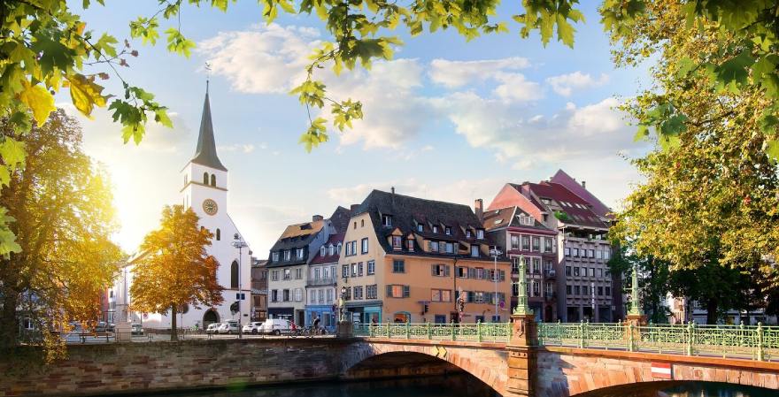 Wilhelmskirche in Strassburg im Sonnenschein mit Brücke im Vordergrund