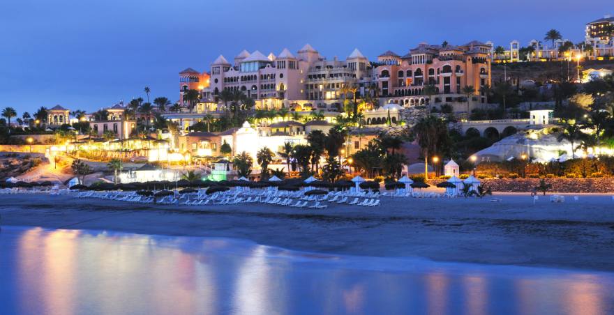 Blick auf Strand und Häuser in der Dämmerung am Playa del Duque, Teneriffa