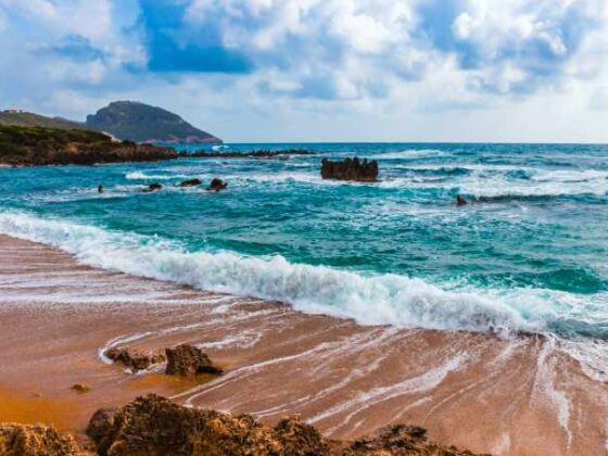 Strand mit Wellen an Bucht bei Romanos, Peloponnes