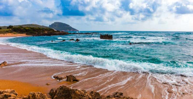 Strand mit Wellen an Bucht bei Romanos, Peloponnes