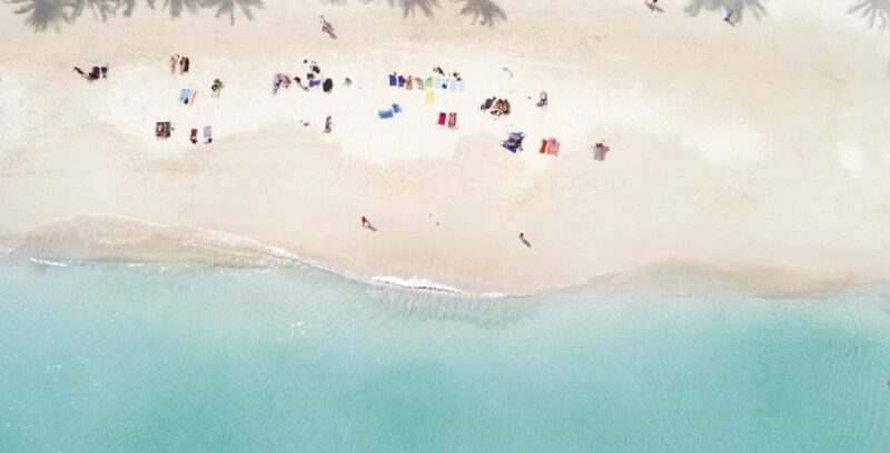 Strandabschnitt in Koh Phangan von Oben mit vielen kleinen Strandbesuchern auf Badetüchern
