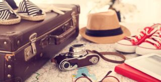 Koffer, Sonnenhut, Sonnenbrille, Kamera, Packliste Sommerurlaub