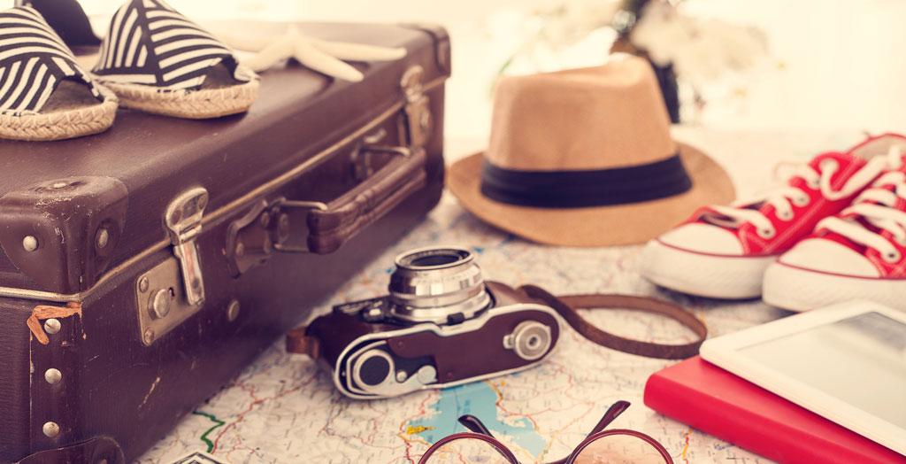 Koffer, Sonnenhut, Sonnenbrille, Kamera, Packliste Sommerurlaub