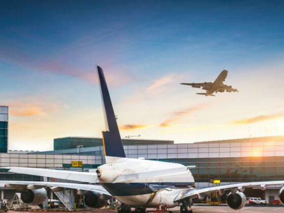 Flughafen mit Flugzeug am Boden und startendem Flugzeug in der Luft