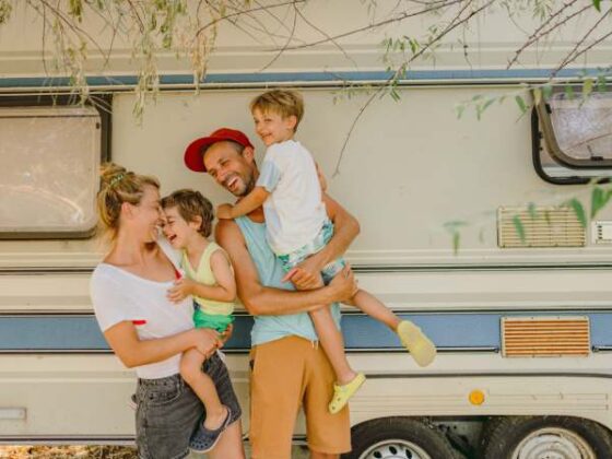 Familie mit zwei Kindern vor Campingbus