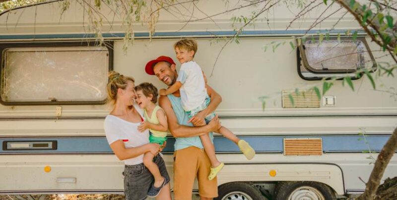 Familie mit zwei Kindern vor Campingbus