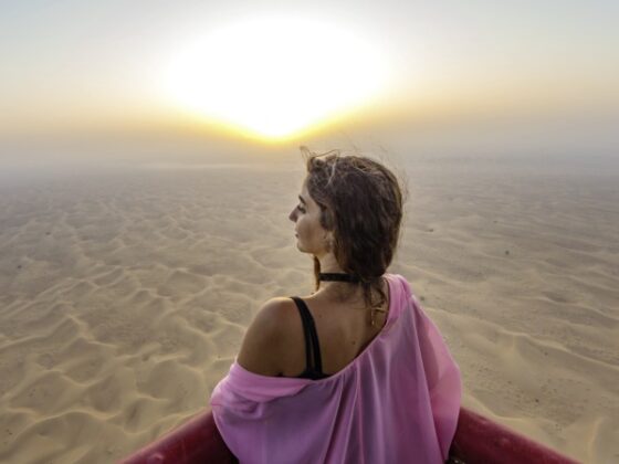 Frau in Wüste bei Sonnenaufgang