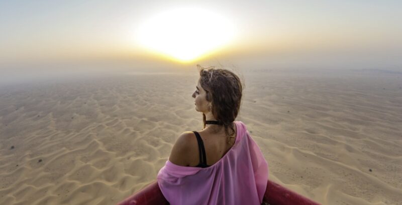 Frau in Wüste bei Sonnenaufgang