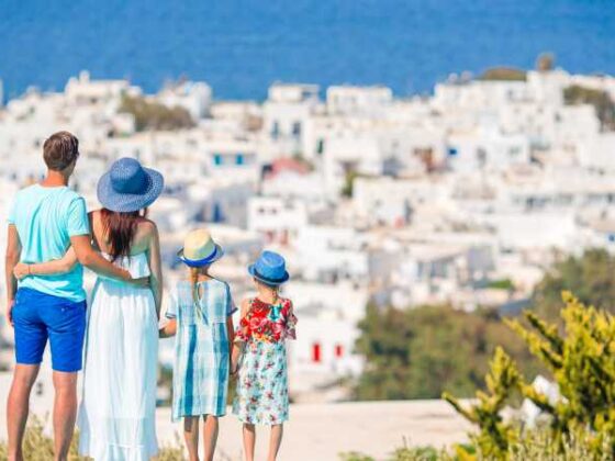 Mutter, Vater und zwei Kinder blicken auf Stadt und Meer in Griechenland