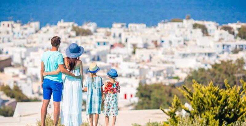 Mutter, Vater und zwei Kinder blicken auf Stadt und Meer in Griechenland