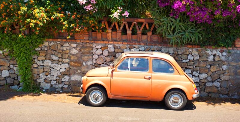 Gelber Fiat (Auto) vor einer Mauer in Italien