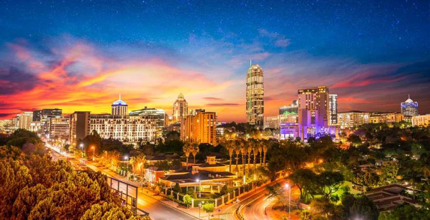 Sandton-Stadt bei Nacht mit Dämmerung und Sternen am Himmel, Gauteng