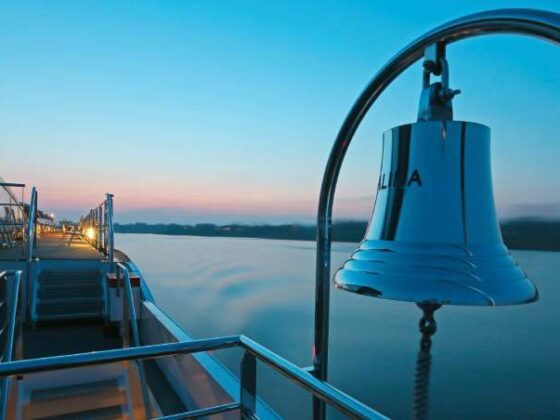 Schiffsdeck und Schiffsglocke im Sonneuntergang