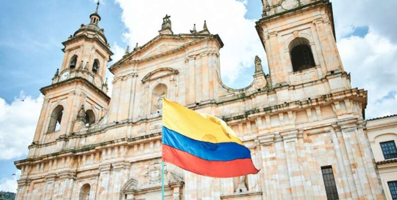 Primada Kathedrale in Bogota mit kolumbianischer Flagge im Vordergrund