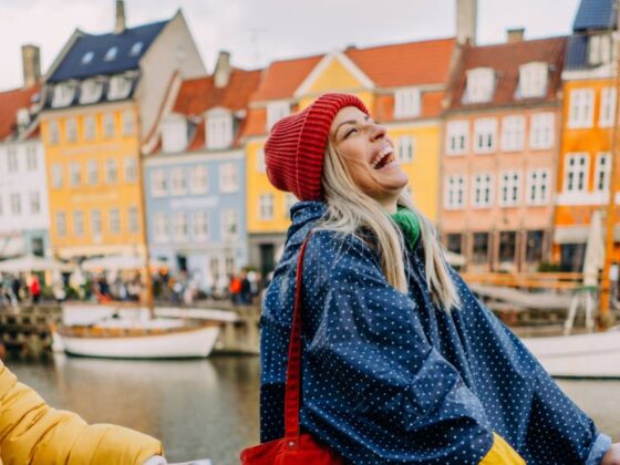 Kopenhagen Geheimtipps: lachende Frauen auf Fahrrädern vor bunten Häusern in Kopenhagen