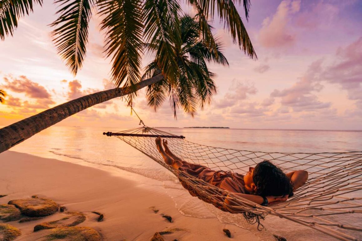 Frau in Hängematte am Strand auf den Malediven