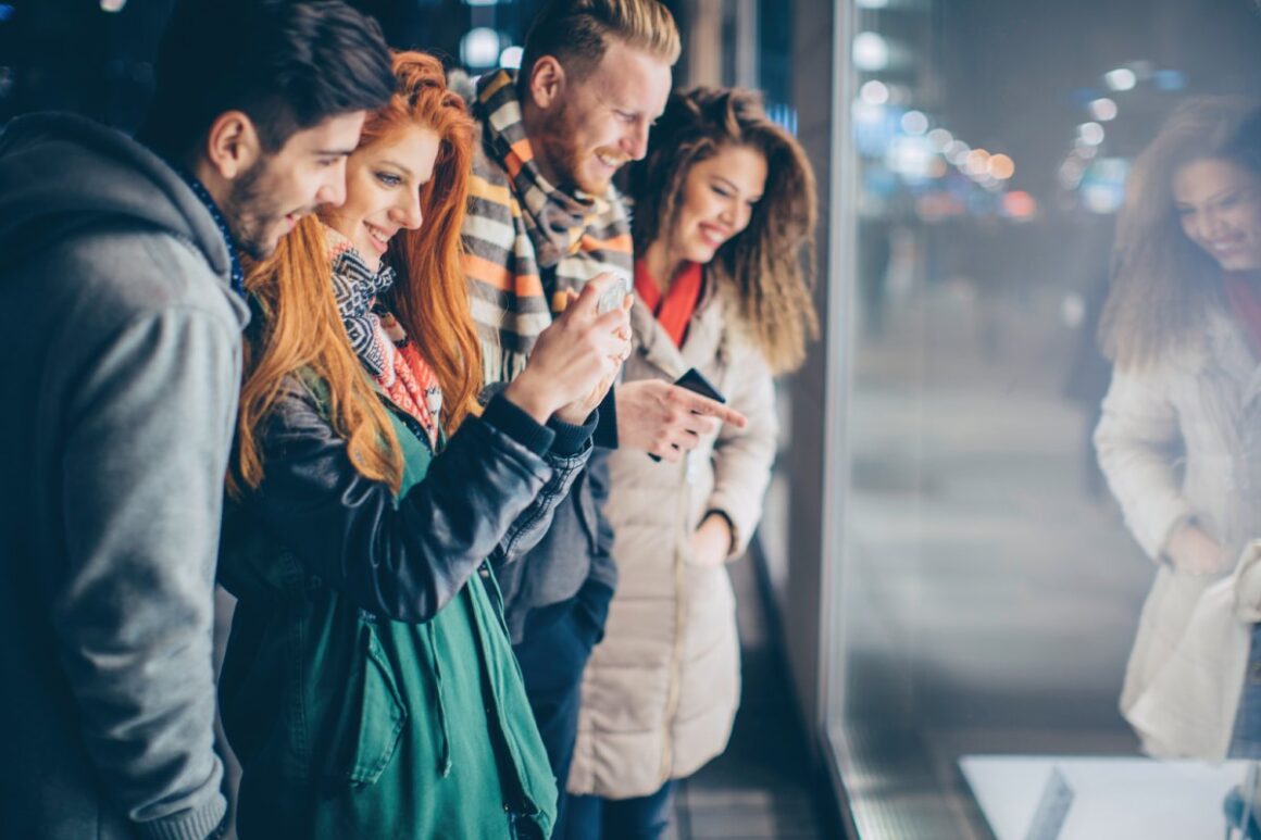 Lachende junge Menschen beim Window Shopping