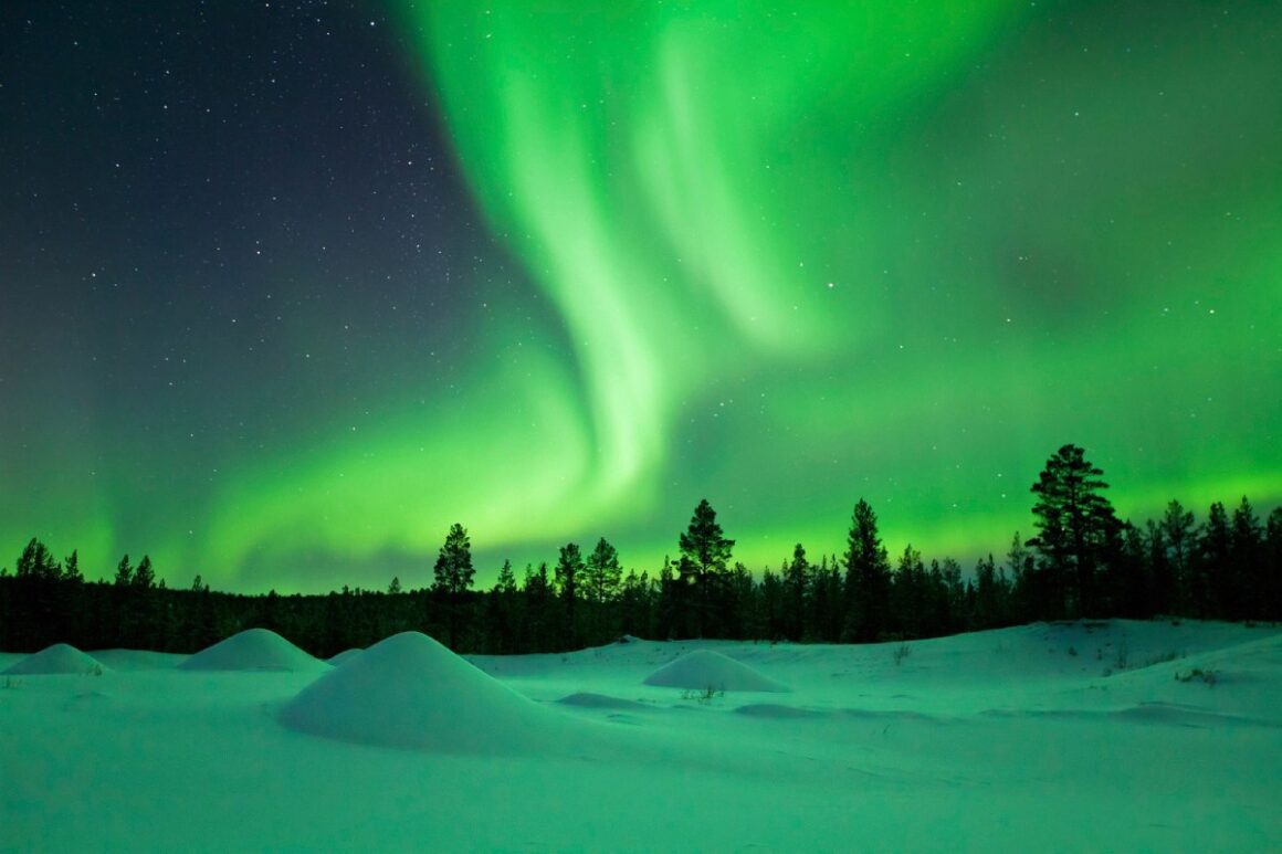 Nordlichter (Aurora borealis) über Schnee-Landschaft im Winter, Lappland, Finnland