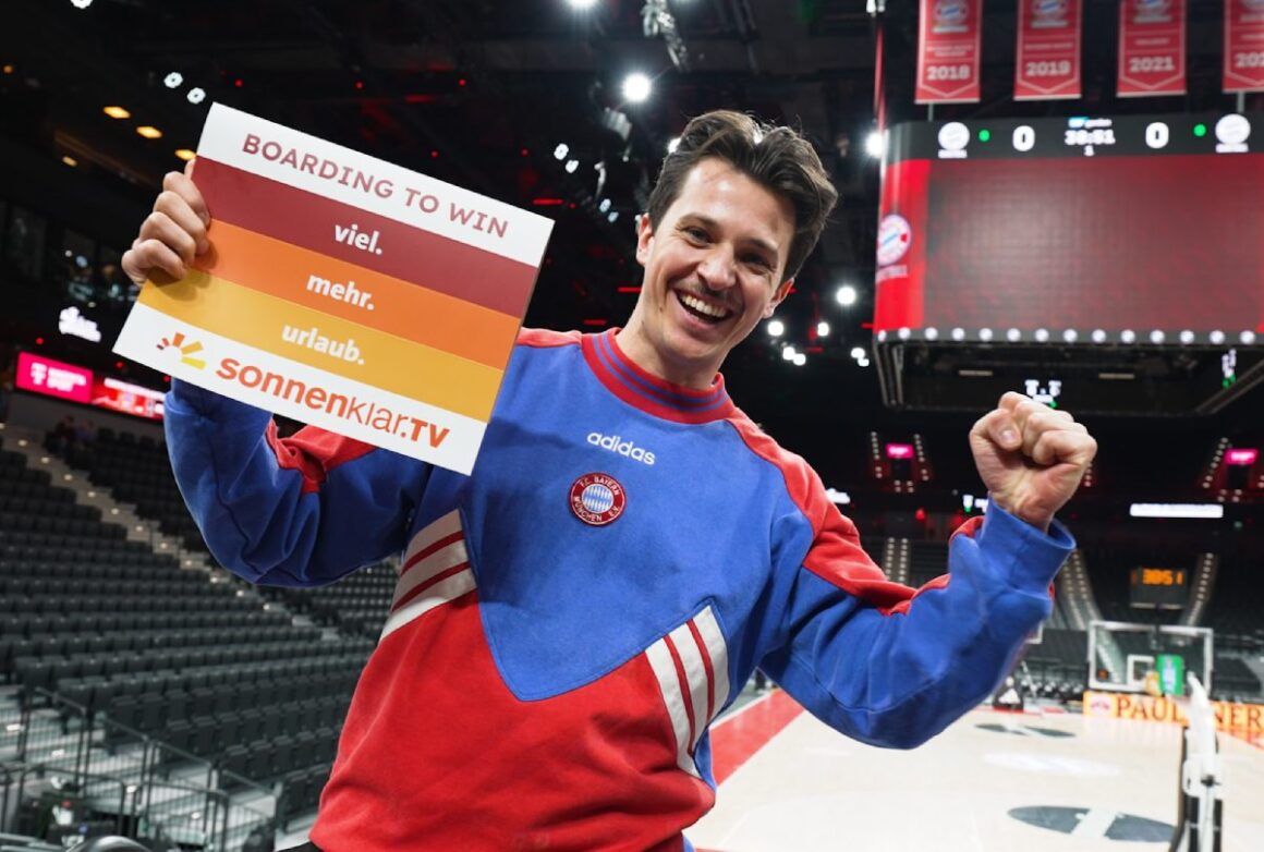 sonnenklar.TV-Redakteuer mit gebrandeter Klatschpappe in SAP Arena