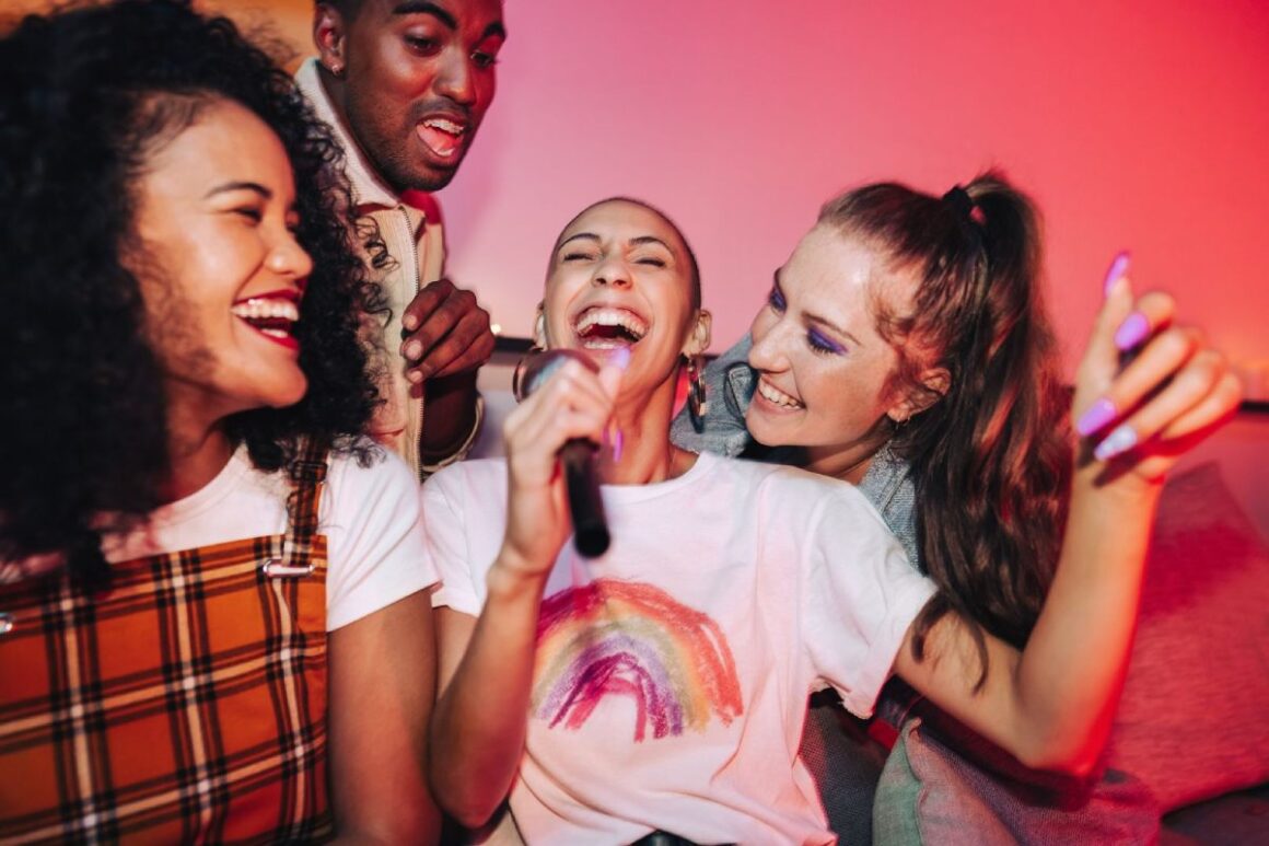 4 lachende Personen singen Karaoke