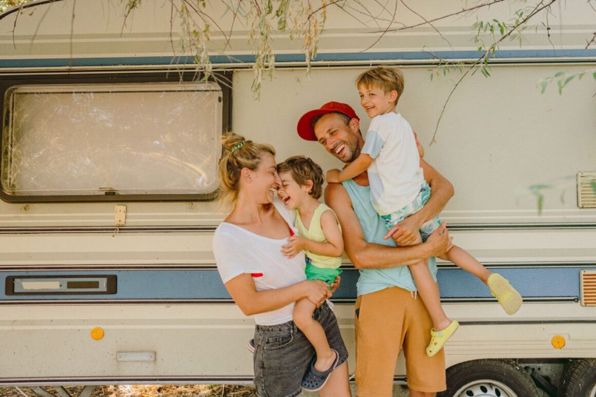 Familie mit zwei Kindern vor Campingbus