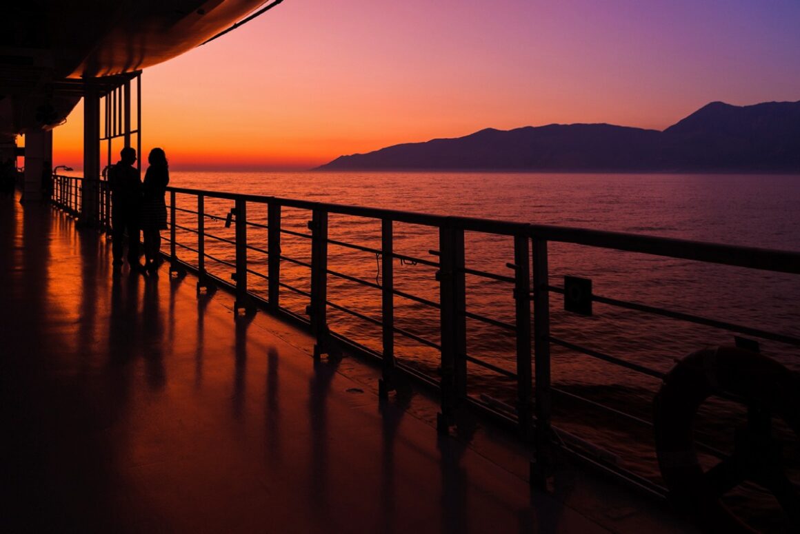 Paar an Deck von Kreuzfahrtschiff im Sonnenuntergang