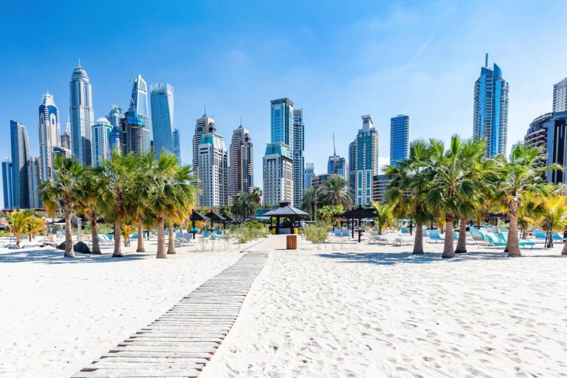 Dubai Skyline mit Wolkenkratzern und Plamen vom Strand aus