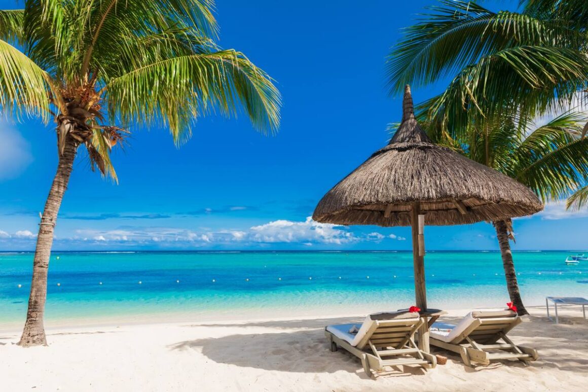 Strand mit Palmen und Sonnenschirm auf Mauritius