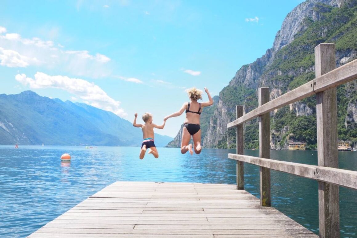 Mutter und Kind springen in den Gardasee