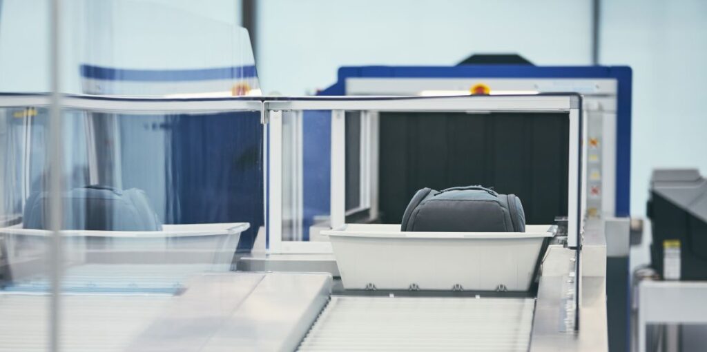 Koffer am Scanner der Sicherheitskontrolle am Flughafen