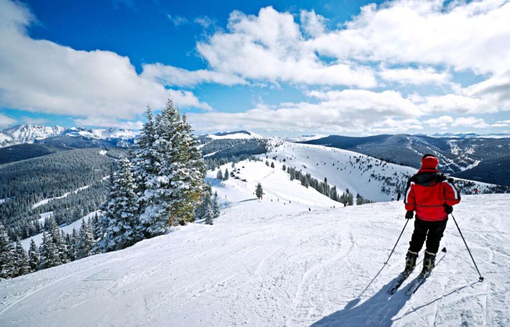 Skifahrer in schwarz-roter Kleidung auf Skipiste