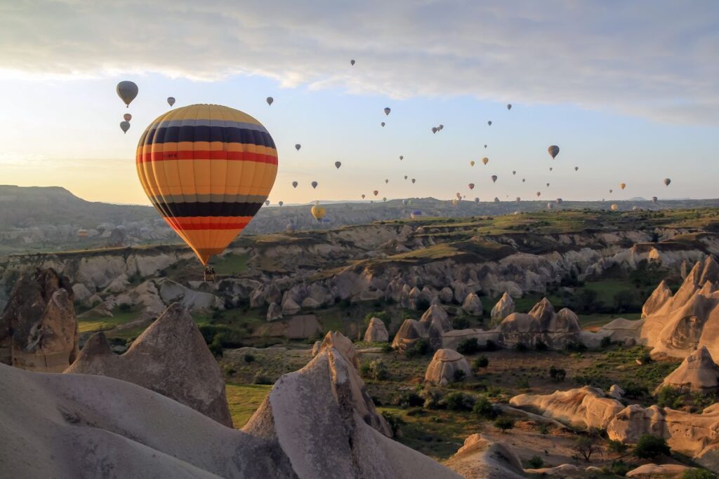 Türkei-Urlaub wird 2026 teurer: Wie Inflation und Lira-Kurs die Reisekasse beeinflussen Zahlreiche Ballons schweben zum Sonnenuntergang über Kappadokien in der Türkei.